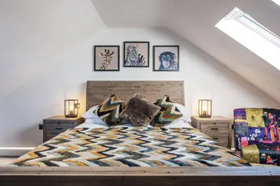 a bedroom with a bed and some pictures on the wall at Porthleven View in Porthleven