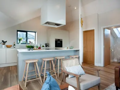 a kitchen with a counter and stools in a room at Rosefern in Tintagel