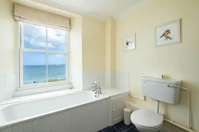 a bathroom with a tub and a toilet and a window at Bellevue, Port Isaac Bay Holidays in Port Isaac