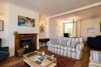 a living room with a couch and a fireplace at Bellevue, Port Isaac Bay Holidays in Port Isaac