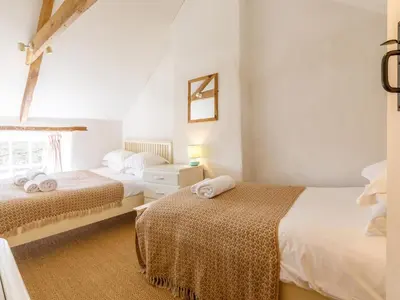 a bedroom with two beds and a window at Aaron's Cottage in Bodmin
