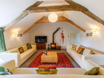 a living room with white couches and a fireplace at Aaron's Cottage in Bodmin