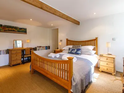 a bedroom with a large wooden bed in a room at Aaron's Cottage in Bodmin