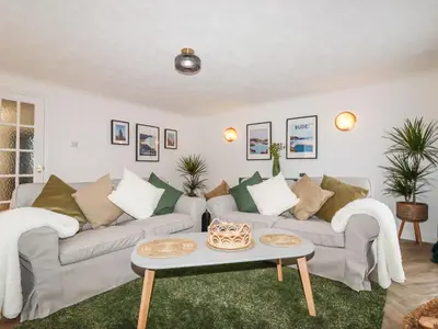 a living room with two couches and a table at Badgers Sett in Tintagel