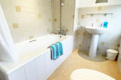 a bathroom with a tub and a sink and a toilet at Morwenna, Port Isaac Bay Holidays in Port Isaac