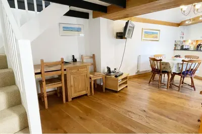 a kitchen and dining room with a table and chairs at Morwenna, Port Isaac Bay Holidays in Port Isaac