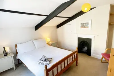 a bedroom with a bed and a fireplace at Morwenna, Port Isaac Bay Holidays in Port Isaac