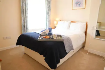 a bedroom with a bed with a tray of food on it at Waypast, Port Isaac Bay Holidays in Port Isaac