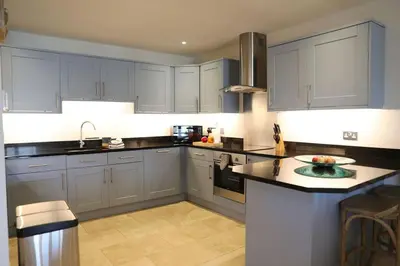 a kitchen with blue cabinets and a counter top at Cockleshell, Port Isaac Bay Holidays in Port Isaac