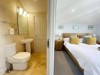 a bathroom with two beds and a toilet and a sink at Cockleshell, Port Isaac Bay Holidays in Port Isaac