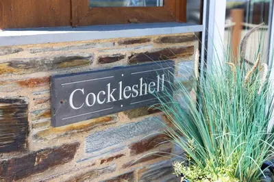 a sign on the side of a brick building at Cockleshell, Port Isaac Bay Holidays in Port Isaac