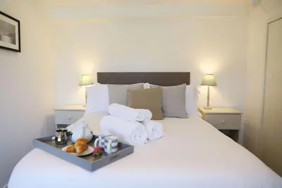 a white bed with towels and a tray of food on it at The Rockies, Port Isaac Bay Holidays in Port Isaac