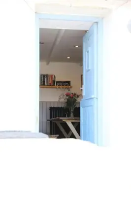 an open door into a room with a table with flowers at The Rockies, Port Isaac Bay Holidays in Port Isaac