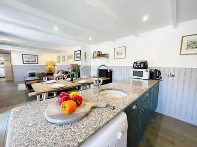 a kitchen with a counter with a bowl of fruit on it at The Rockies, Port Isaac Bay Holidays in Port Isaac