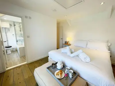 a white bed in a room with a tray of food on it at The Rockies, Port Isaac Bay Holidays in Port Isaac