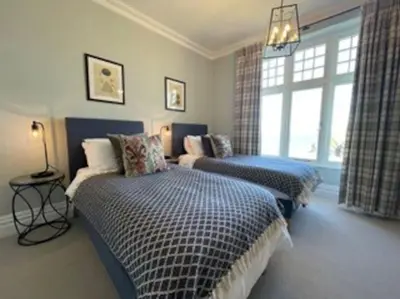 a bedroom with two beds and a window at Folly 1, Port Isaac Bay Holidays in Port Isaac