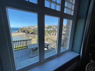 a window with a view of a bench on a balcony at Folly 1, Port Isaac Bay Holidays in Port Isaac