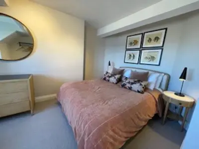 a bedroom with a large bed and a mirror at Folly 1, Port Isaac Bay Holidays in Port Isaac
