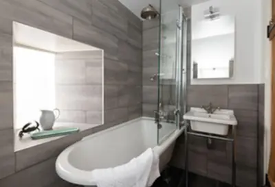 a bathroom with a bath tub and a sink at Kicker Cottage, Port Isaac Bay Holidays in Port Isaac