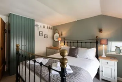 a bedroom with a bed and a green wall at Kicker Cottage, Port Isaac Bay Holidays in Port Isaac