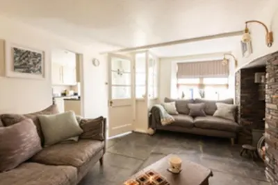 a living room with a couch and a fireplace at Kicker Cottage, Port Isaac Bay Holidays in Port Isaac