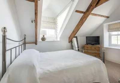 a white bedroom with a bed and a tv at Upper Deck, Port Isaac Bay Holidays in Port Isaac
