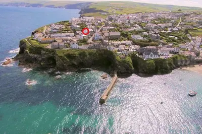 a small island in the ocean with a red flag at Upper Deck, Port Isaac Bay Holidays in Port Isaac
