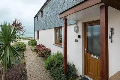 a house with a wooden door and a walkway at Sea Gem, Port Isaac Bay Holidays in Port Isaac