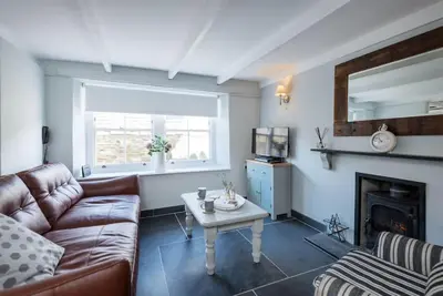 a living room with a couch and a fireplace at Scuppers, Port Isaac Bay Holidays in Port Isaac