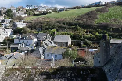 a view of a town with houses and a hill at Scuppers, Port Isaac Bay Holidays in Port Isaac