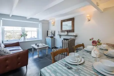 a living room with a table and a couch at Scuppers, Port Isaac Bay Holidays in Port Isaac