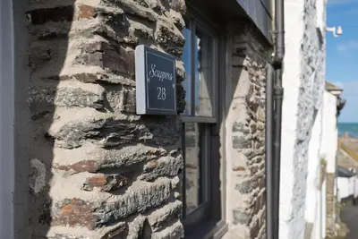 a sign on the side of a brick building at Scuppers, Port Isaac Bay Holidays in Port Isaac