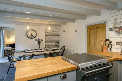a kitchen with a table and a dining room at Windlass, Port Isaac Bay Holidays in Port Isaac