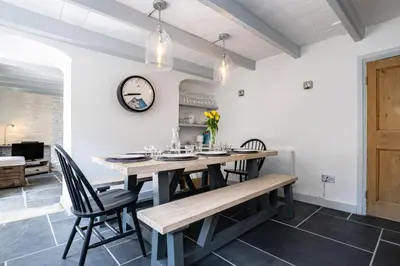 a dining room with a table and chairs at Windlass, Port Isaac Bay Holidays in Port Isaac