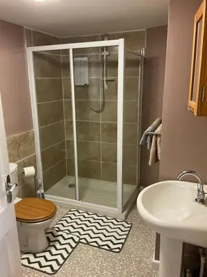 a bathroom with a shower and a toilet and a sink at Comfy and welcoming 2 bedroom Annex. in Padstow