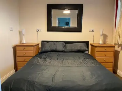 a bedroom with a bed and a mirror on the wall at Comfy and welcoming 2 bedroom Annex. in Padstow