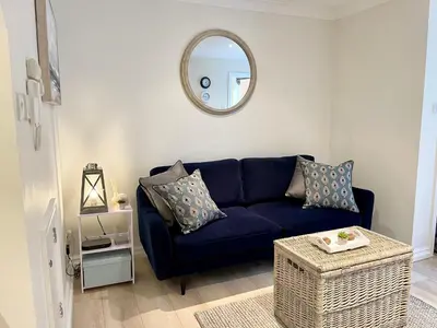 a blue couch in a living room with a mirror at The Little Snug in St Ives in St Ives