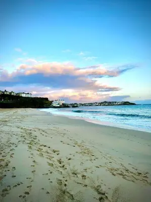 a beach with footprints in the sand and the ocean at The Little Snug in St Ives in St Ives