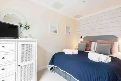 a bedroom with a blue bed with a tv on it at The Little Snug in St Ives in St Ives