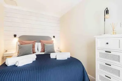 a bedroom with a blue bed with towels on it at The Little Snug in St Ives in St Ives