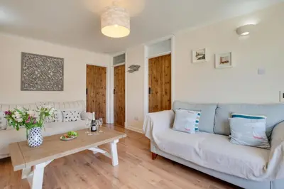 a living room with a couch and a table at Ebrel, Port Isaac Bay Holidays in Port Isaac