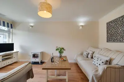 a living room with a couch and a table at Ebrel, Port Isaac Bay Holidays in Port Isaac