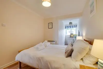 a bedroom with a bed with white sheets and pillows at Ebrel, Port Isaac Bay Holidays in Port Isaac