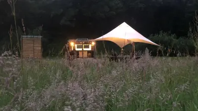 a tent in the middle of a field at night at Exclusive Use Riverside Landpods at Wildish Cornwall in Bodmin