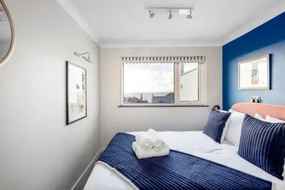 a bedroom with a bed with two towels on it at Sunset Beach House Porthleven in Porthleven
