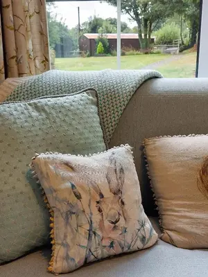 a couch with pillows with a picture of a dog on it at The Old Farmhouse in Michaelstow