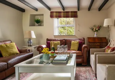 a living room with leather furniture and a coffee table at The Old Farmhouse in Michaelstow