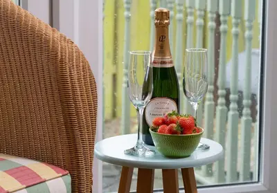 a bottle of champagne and two glasses on a table with strawberries at The Old Farmhouse in Michaelstow