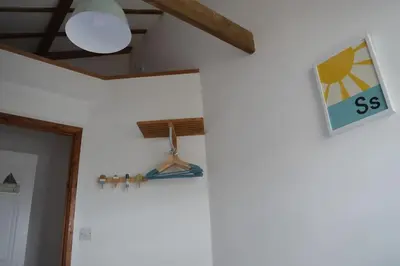 a room with a lamp and a sign on the wall at 2-bedroom cottage in heart of St Ives w/ parking in St Ives