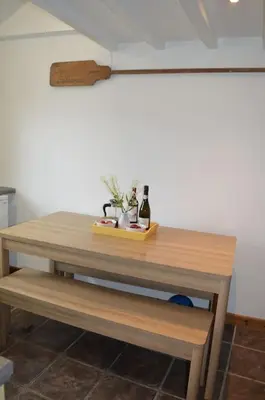 a wooden table with a bottle of wine on it at 2-bedroom cottage in heart of St Ives w/ parking in St Ives